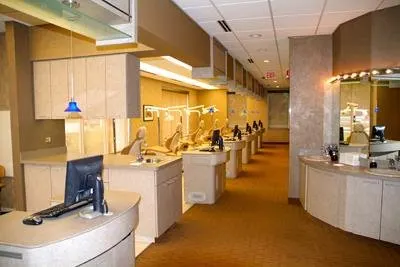 Modern orthodontic office interior with reception desk, treatment stations, and professional dental workspace.