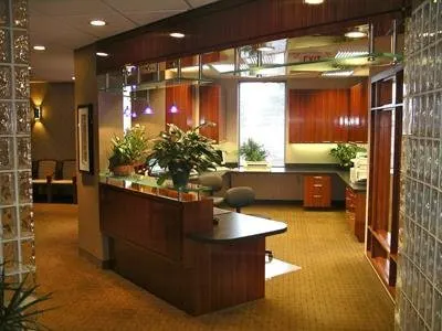 Modern orthodontic office reception area with wooden desk, orange accent walls, and professional waiting space.