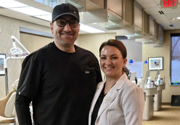 Two people smiling together in a modern orthodontic office reception area.
