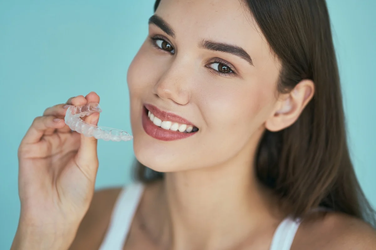 woman holding invisalign clear aligner at Parker Orthodontics